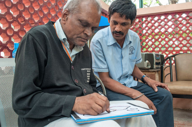 An elderly member colouring a drawing at the Day Care Centre