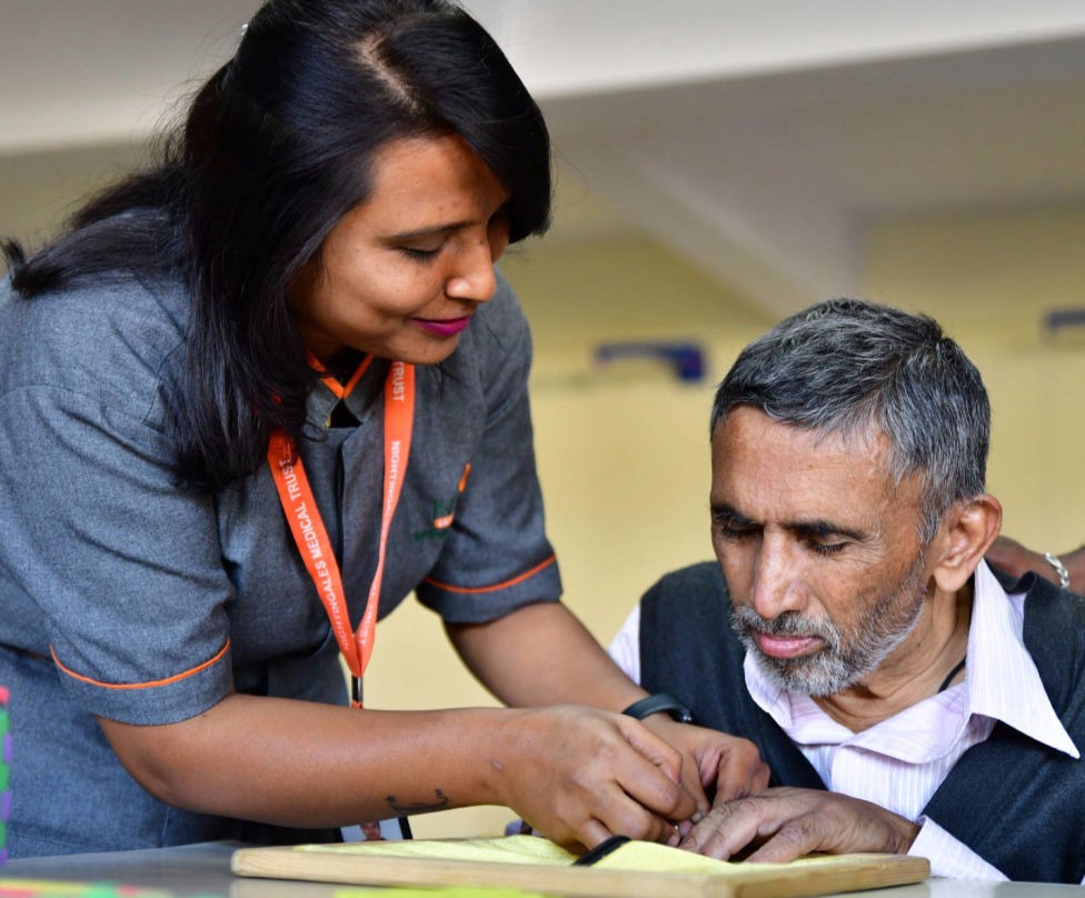 A carer at one of NMT's Day Care Centre tends to an elderly