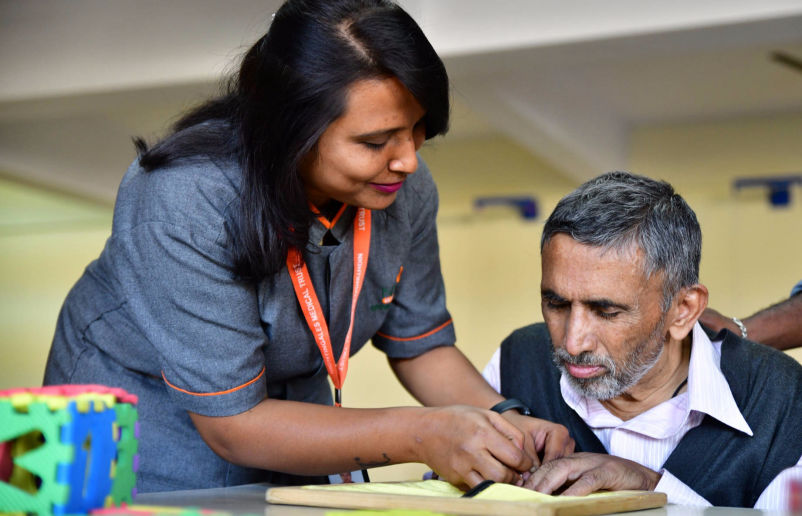 An aide with a member at NMT's Dementia Day Care Centre